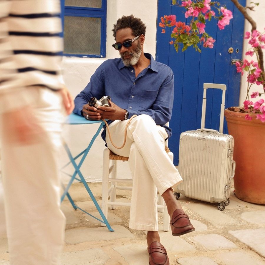 man seated focused on the camera in his hand