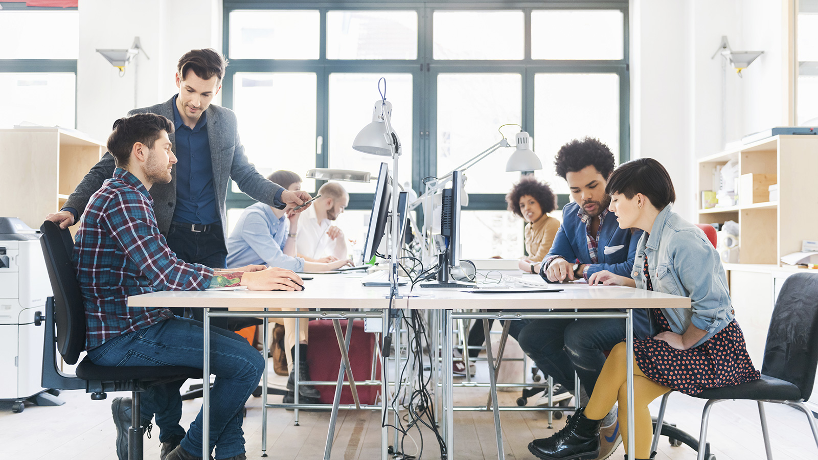 Office workers collaborating at their desks.  