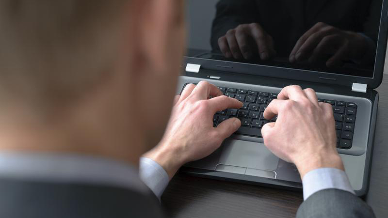 Mãos masculinas digitando em um notebook
