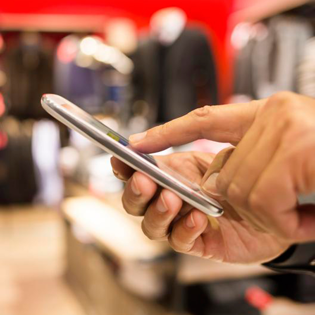 Close up of hands holding a mobile phone.
