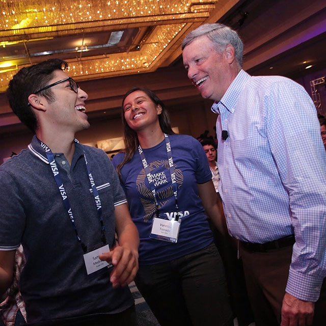 Two interns with Visa CEO, Al Kelly at Global Intern Summit