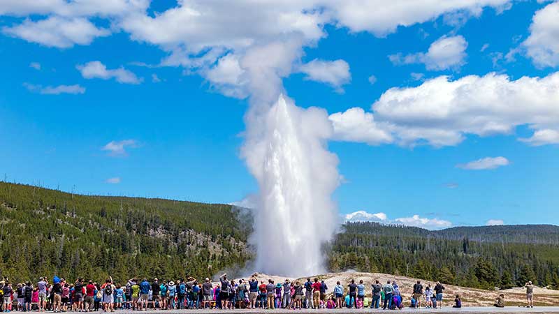 Big group of people standing near a geyser.