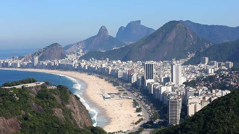 View of beach, city and mountains.