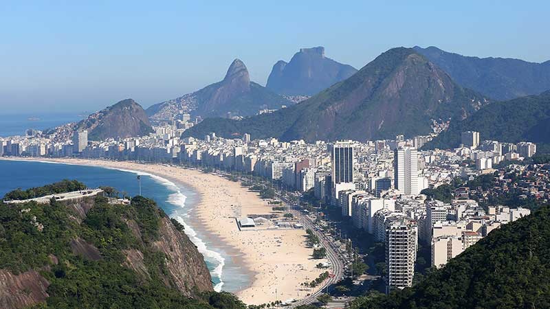 View of beach, city and mountains.