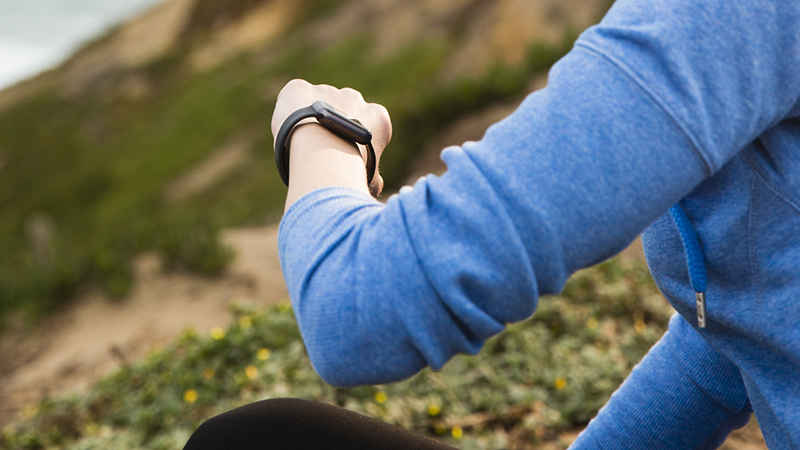 Mulher fazendo trilha usando dispositivos vestíveis (wearables)