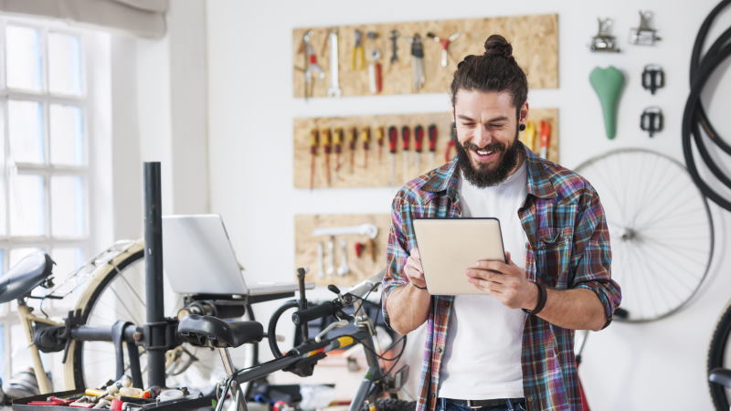Man on tablet in bike shop