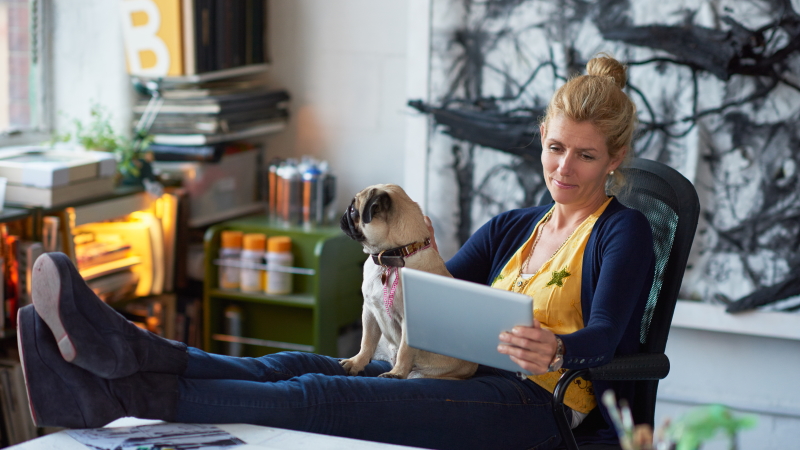 Woman with dog looking at tablet