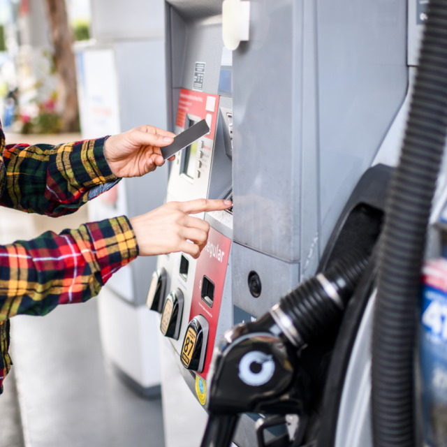 Woman paying for fuel at pump