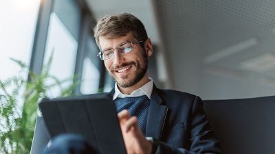 Businessperson smiles while using a tablet